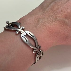 Br13. Silver colored bracelet with clasp.